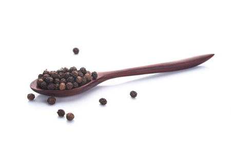 black pepper in a wooden spoon against white background