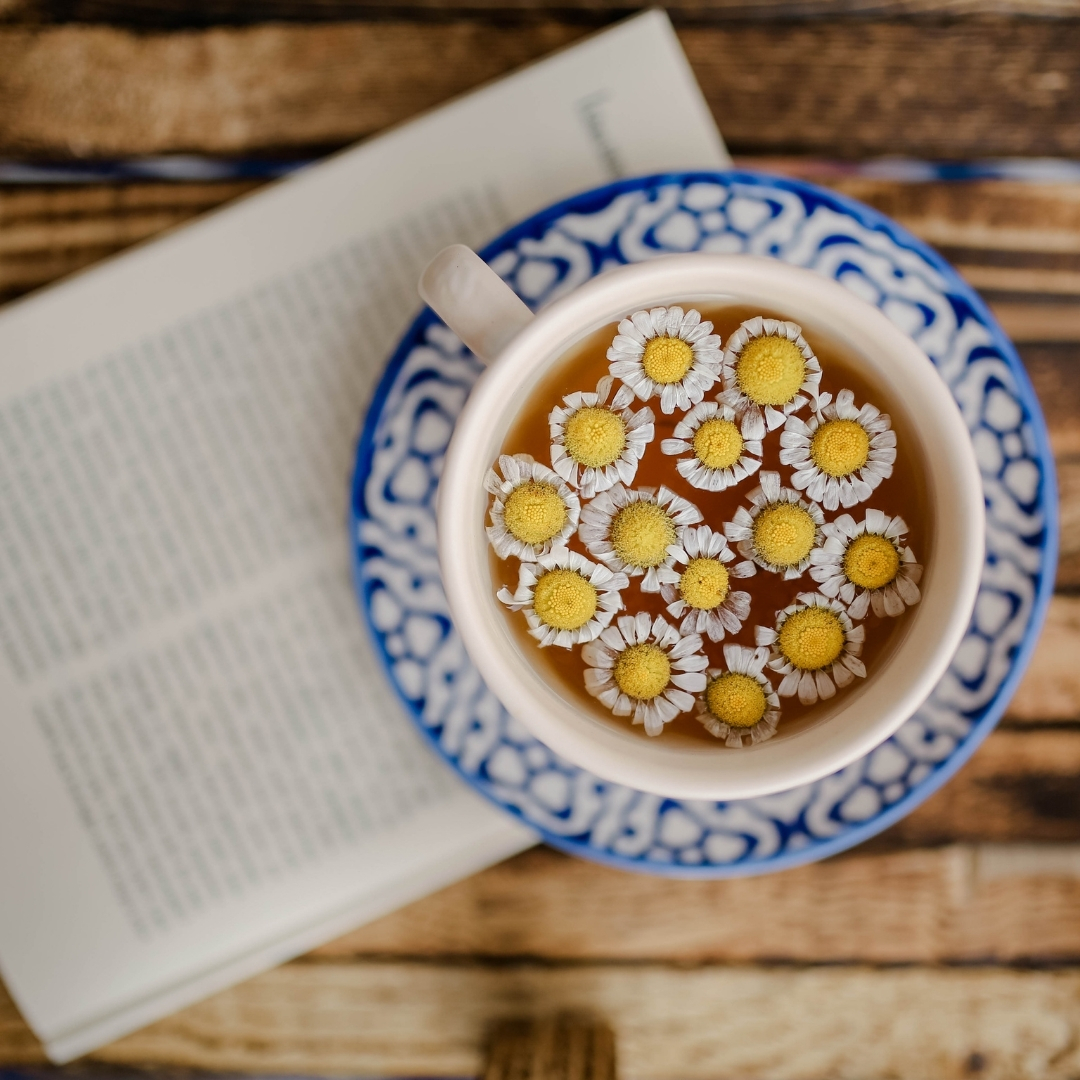 a cup of chamomile tea with chamomile flowers